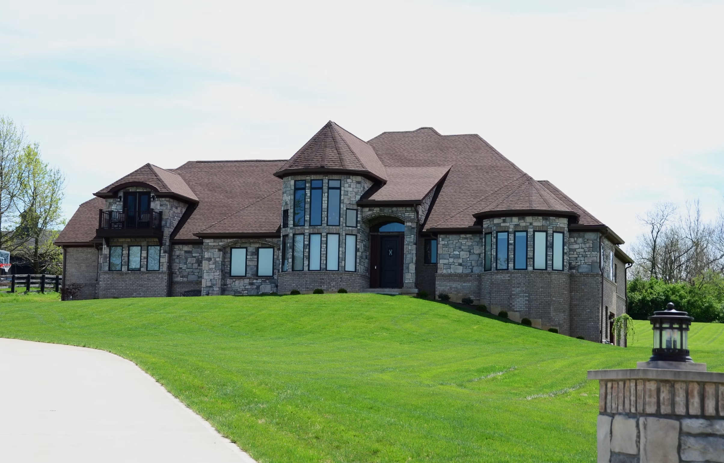 Stone residence with dramatic pitched rooflines and a landscaped lawn